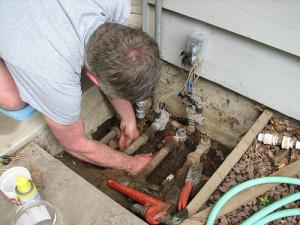 a tech checks the connections to the underground pump system