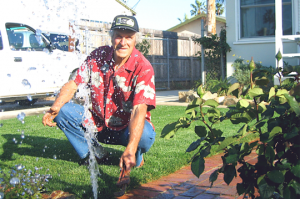a Flower Mound sprinkler repair tech checks a blown out head